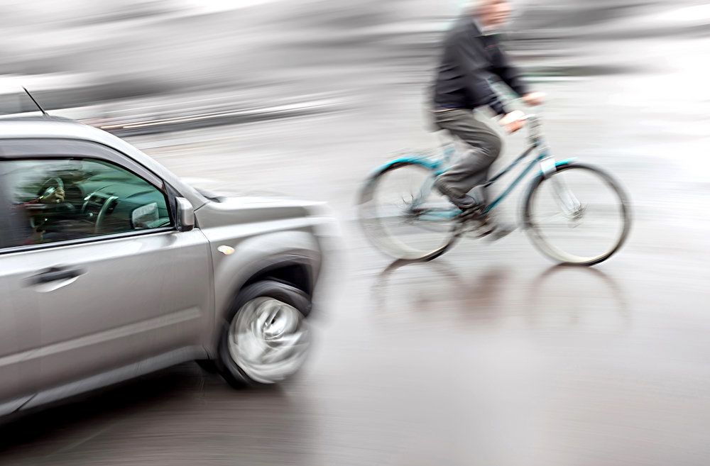 A blurry photo of an oncoming car and a bicycle